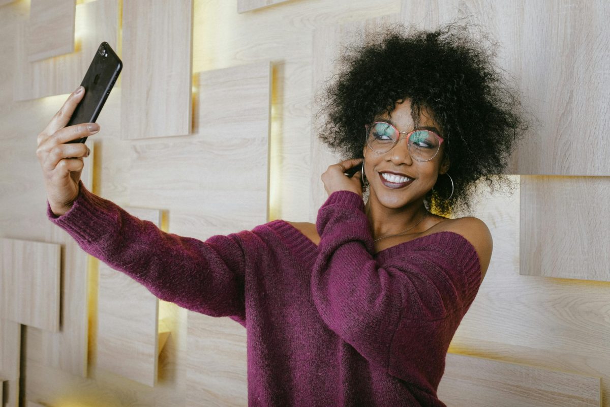 Photo of a smiling young woman taking a selfie.