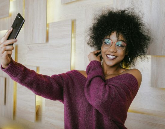 Photo of a smiling young woman taking a selfie.